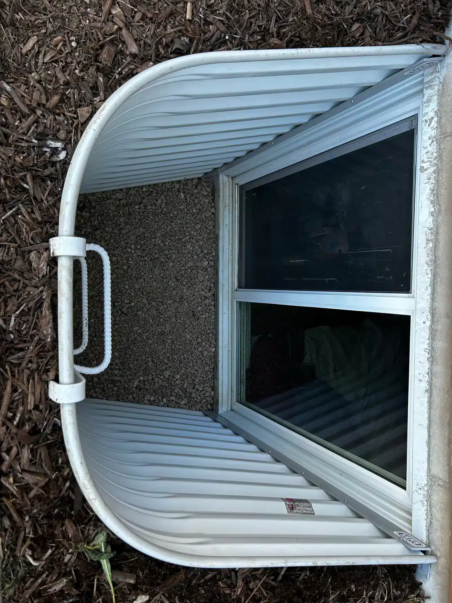 Window well filled with rainwater showing drainage failure issue in Fort Collins home